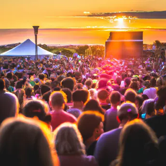 Festival crowd at sunset in front of an outdoor stage